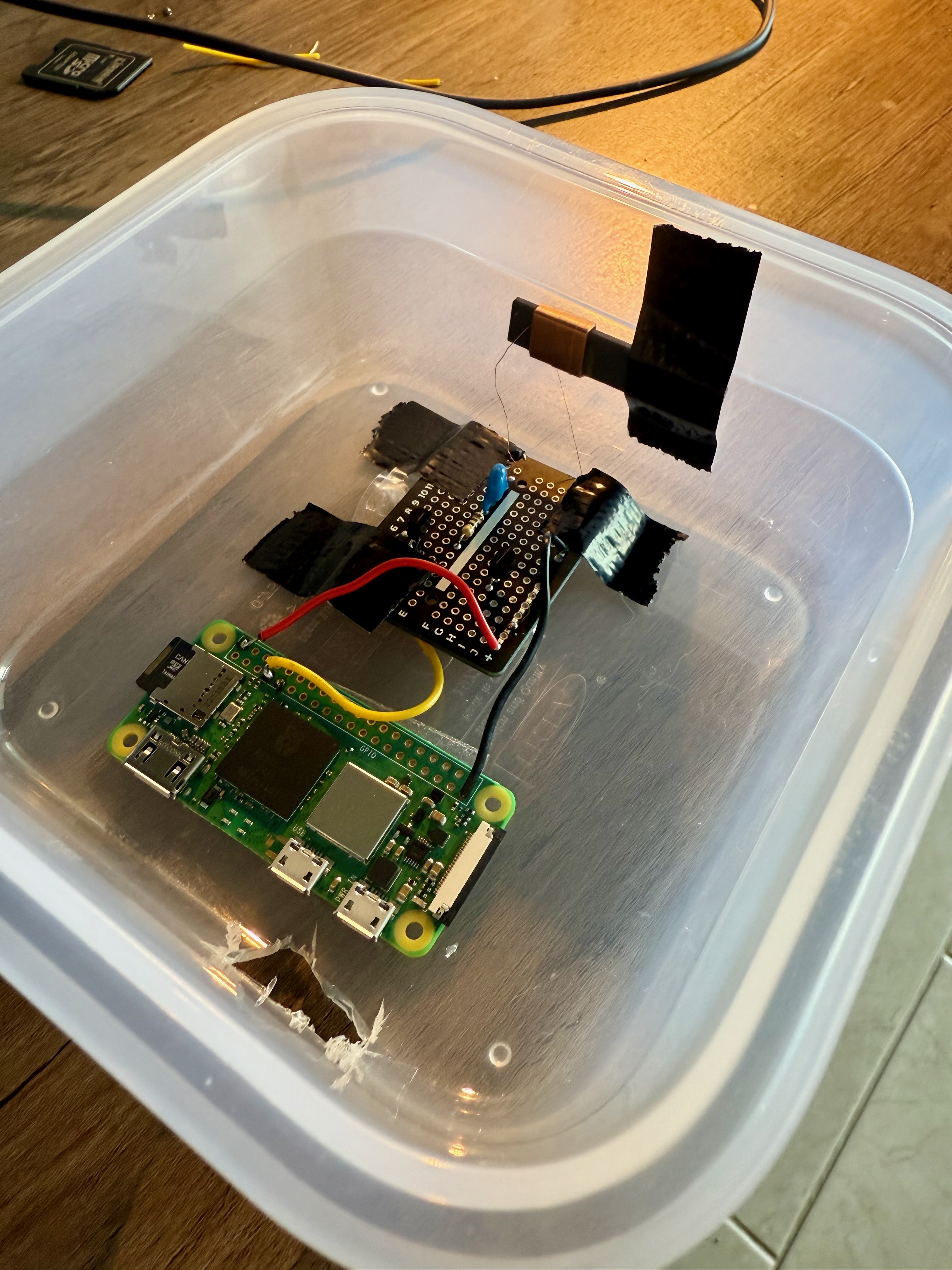 The complete transmitter assembled inside an open Tupperware container