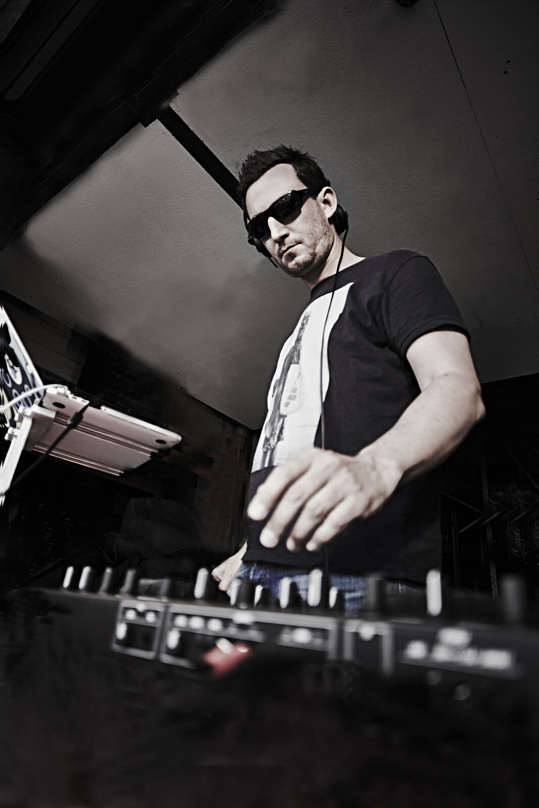 DJ behind the decks, low angle black and white promo shot